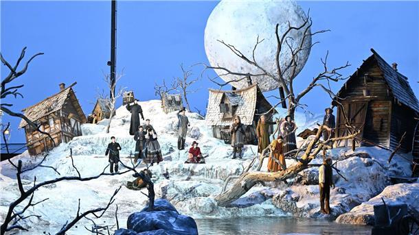 Auf dem Bodensee ist für die Inszenierung ein halb im Wasser versunkenes Dorf entstanden - mit schneebedeckten Hütten, kahlen Bäumen und einem riesigen Mond.