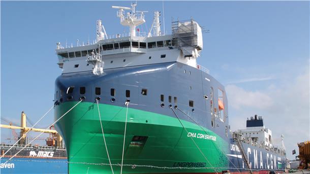 Ein Containerschiff liegt in einem Hafen.