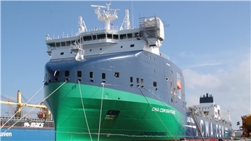 Ein Containerschiff liegt in einem Hafen.