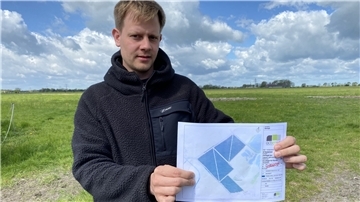  Christoph Geil hält einen Plan in die Kamera.