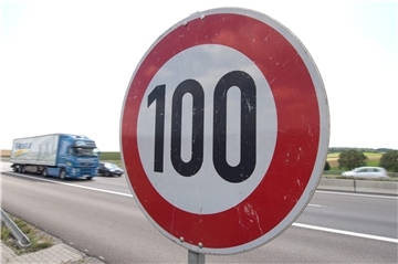 Ein Laster und Autos fahren auf einer Autobahn an einem Tempo-100-Schild vorbei. Auf der A27 gilt seit dieser Woche zwischen Neuenwalde und Debstedt eine neue Höchstgeschwindigkeit von 100 km/h. Grund ist der marode Zustand der rechten Fahrspur. Eine umfassende Sanierung ist erst für 2026 geplant.