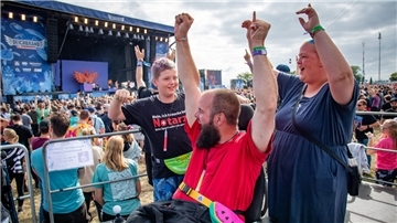 Auf der Rolli-Tribüne feiern Vanessa, Robin und Raphael Meinert (von rechts) vor der Water Stage auf dem Deichbrand-Festival zu den Sounds der Orsons.