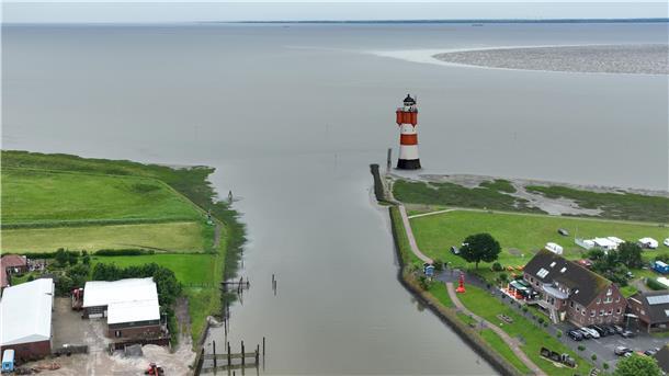 Die Hafeneinfahrt von Fedderwardersiel in einer Fotomontage. Rechts steht der Leuchtturm Roter Sand. Butjadingen hofft, bei der Standort-Frage den Zuschlag zu erhalten.