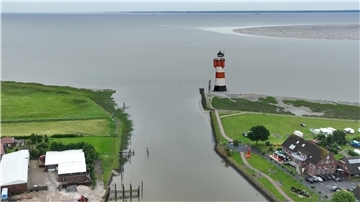 Die Hafeneinfahrt von Fedderwardersiel in einer Fotomontage. Rechts steht der Leuchtturm Roter Sand. Butjadingen hofft, bei der Standort-Frage den Zuschlag zu erhalten.