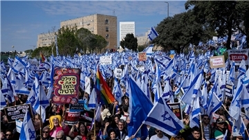 Auf einer Demonstration in Jeruslaem schwenken Protestierende isreaelische Nationalflaggen.
