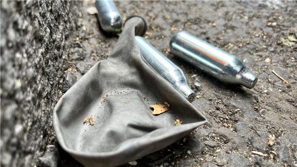 Ärztekammer: Verbot von Lachgas-Verkauf an Minderjährige Auf einer Straße liegen mehrere Gaspatronen und ein Luftballon.