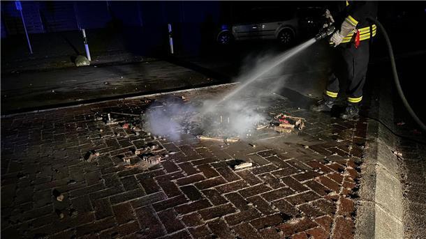 Kommissar Zufall hilft der Feuerwehr Schiffdorf an Silvester Ein Feuerwehrmann löscht einen kleinen Brand auf einer Verkehrsinsel.