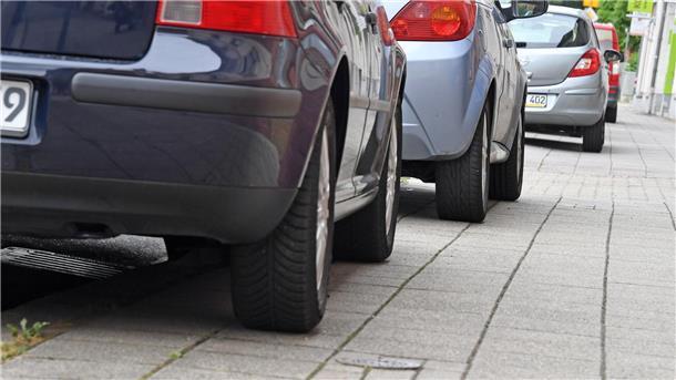 Auf Gehwegen parkende Autos versperren Rollstühlen oder Kinderwagen häufig den Weg. (Symbolbild)