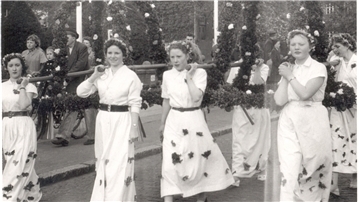 Frauen tragen auf einem Schwarz-Weiß-Foto aus den 50er-Jahren die Kronen für einen Pfingstbaum.