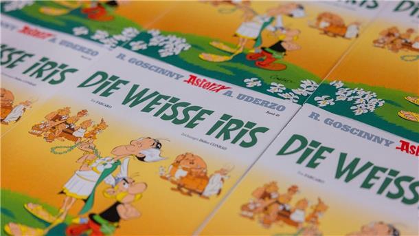 Neuer „Asterix“-Band: Positiv denken statt prügeln Ausgaben des neuen Asterix-Bandes mit dem Titel „Die weiße Iris“ werden in einer Logistikhalle konfektioniert und in Displays für den Einzelhandel verpackt.