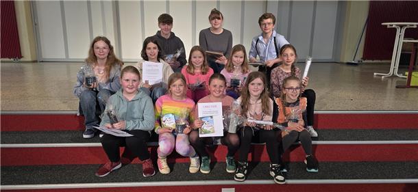 Wesermarsch-Schüler erobern Bezirksentscheid im Plattdeutsch-Lesen Schülerinnen und Schüler sitzen zusammen auf einer Treppe.