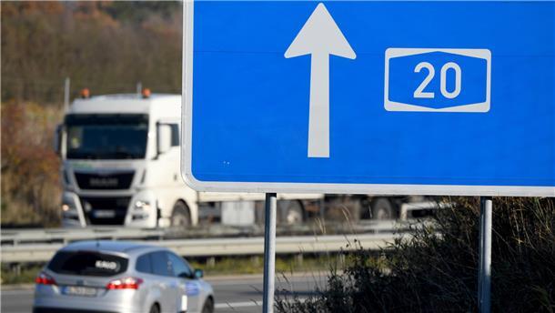 Autos fahren hinter einem Hinweisschild zur A20 auf der Autobahn. Die Autobahn soll nach dem Willen der Unterweser-Anrainer bis nach Niedersachsen ausgebaut werden.