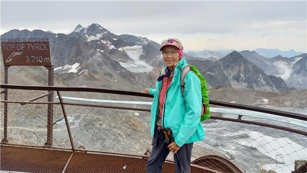 Abenteuerlust mit 79 Jahren: Nordenhamerin überquert die Alpen Frau in Wanderausrüstung vor Berggipfeln