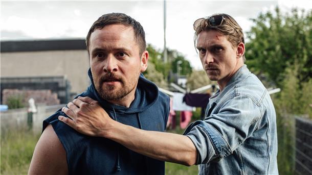 Bastian Barthel (l, Lorris Andre Blazejewski) wird von Adam Schürk (Daniel Sträßer) vorläufig festgenommen.