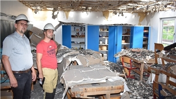 Bauamtsmitarbeiter Christian Blumenberg und Gemeindebrandmeister Robert König (von links) im Werkraum der Grundschule Schwei. Das Inventar ist weitgehend zerstört worden.