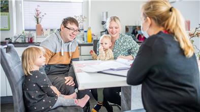 Bauherrenberaterin Elvira Dreier (rechts) zeigt Yvonne und Marvin Holst mit ihren Kindern Fiete und Lotta den Grundrissplan ihres Hauses in Dorum.