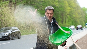 Bayerns Ministerpräsident Markus Söder bringt Saatgut für einen „Bienen-Highway“ in Schwaig bei Nürnberg aus.