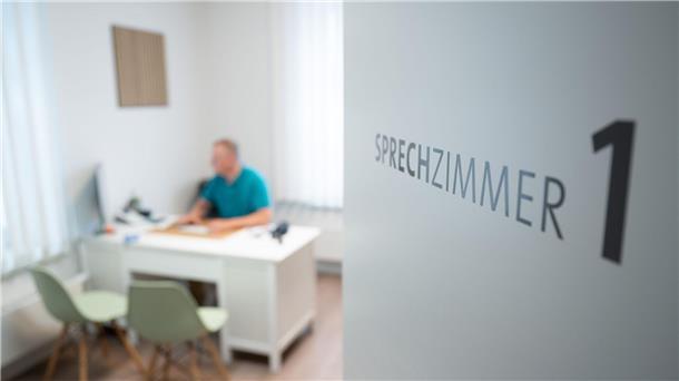 Ein Hausarzt sitzt in einem Sprechzimmer seiner Hausarztpraxis an einem Schreibtisch und arbeitet am Computer. Bei den „Cuxland-Gesprächen“ in Loxstedt diskutieren Experten über die Zukunft der hausärztlichen Versorgung. Im Fokus steht die Neuausrichtung des Kassenärztlichen Notdienstes.
