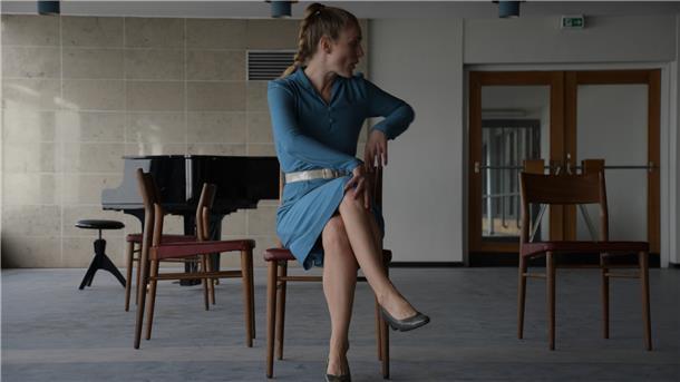 Besonderes Schmuckstück für die Loxstedter Musikschule Eine Frau auf einem Stuhl, im Hintergrund ein schwarzer Flügel.