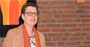 Frau mit Brille spricht bei einer Tagung.
