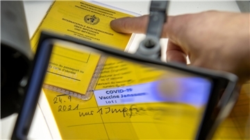 Bei der Kriminalpolizeiinspektion liegen Impfpässe unter einer Lupe, darunter ein aufgeschlagener Impfausweis mit einem Eintrag einer Corona-Impfung. Impfpässe wurden in der Corona-Zeit auch mal gefälscht.