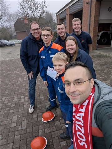 Mehrere Feuerwehrleute stellen sich zu einem Foto auf.
