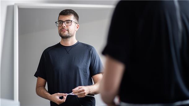 Florian Zinn steht vor dem Spiegel und misst seinen Bauchumfang.
