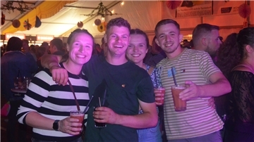 Eine Gruppe feiernder Menschen lacht in die Kamera.