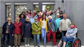 Männer und Frauen haben sich zu einem Gruppenbild aufgestellt
