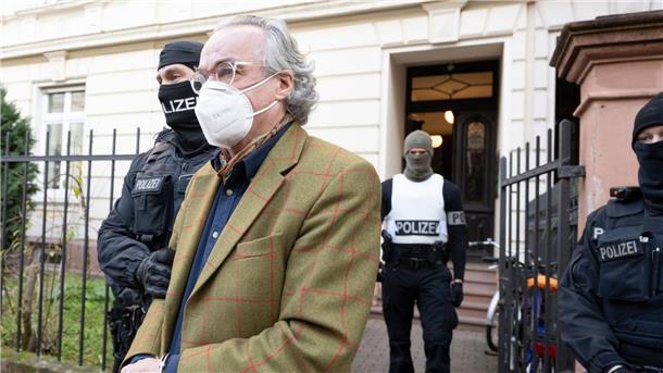 Bei einer Razzia gegen sogenannte Reichsbürger führen Polizisten Heinrich XIII Prinz Reuß (vorn) zu einem Polizeifahrzeug.
