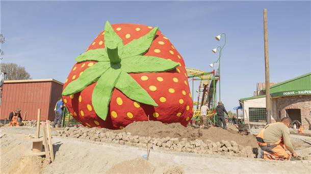 Abenteuer für die ganze Familie: Die schönsten Freizeitparks im Norden Eine überdimensional große Erdbeere, die auf einer Baustelle liegt.
