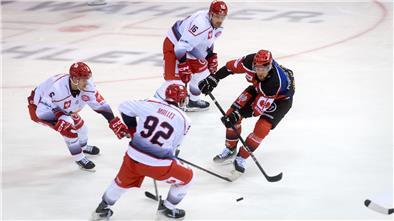 Vier Eishockeyspieler im Kampf um den Puck.