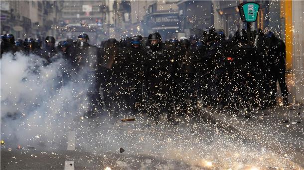 Bereitschaftspolizisten stoßen in Paris mit Demonstranten zusammen.
