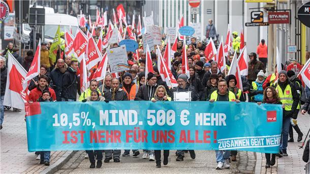 Teilnehmer einer Demonstration zeigen während eines Warnstreiks auf einem Transparent mit der Aufschrift «10,5 Prozent, mindestens 500 Euro mehr ist mehr für Alle!» ihre zentralen Forderungen. 