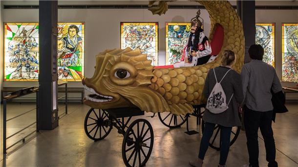 Besucher des Kölner Karnevalsmuseums besichtigen einen originalgetreuen Nachbau des sogenannten „Heldenwagens“ aus dem ersten Kölner Rosenmontagszug von 1823.