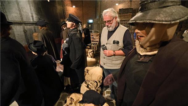 Eine Hafenszene aus dem Jahr 1888. Ein Besucher steht zwischen Puppen, die zeitgemäß gekleidet sind.