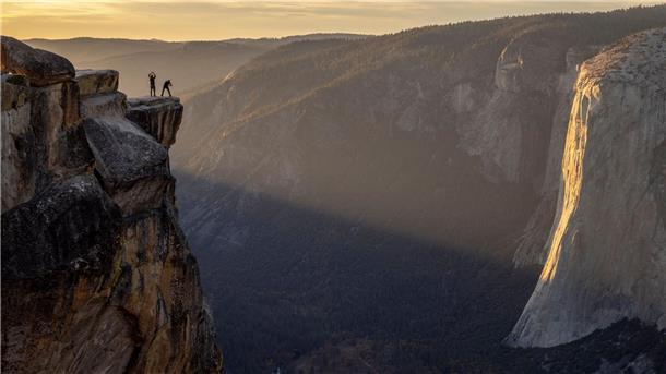 Besucher posieren für ein Foto auf einem Felsvorsprung in der Nähe von Taft Point im Yosemite Nationalpark in den USA.