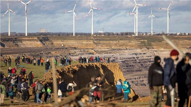 Besucher stehen direkt an der Kante des Tagebaus Garzweiler II in Lützerath.