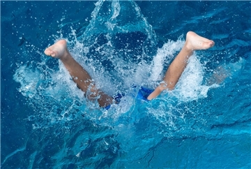  Ein Junge springt ins Wasser. 