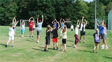 Kinder und Jugendliche beim Aufwärmen auf dem Stollhammer Sportplatz