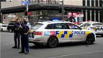 Bewaffnete neuseeländische Polizisten stehen an einer Straßensperre, nachdem in Auckland Schüsse gefallen waren.