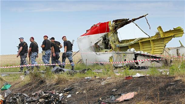 Bewaffnete Separatisten im Juli 2014 neben einem Trümmerteil der Malaysia-Airlines-Maschine im Osten der Ukraine.
