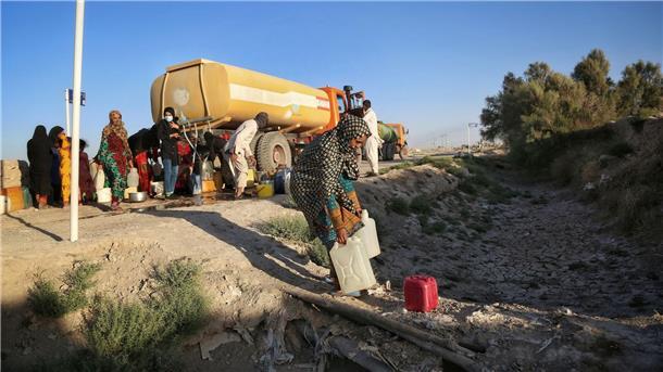 Wasser-Streit: Nachbarstaaten zwischen Frieden und Konflikt Bewohner holen nahe des ausgetrockneten Hamun-Sees in der iranischen Provinz Sistan und Belutschistan Wasser von einem Tankwagen.