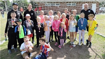 Viele Kinder halten stolz ihre Medaille der Kinderolympiade in die Kamera.