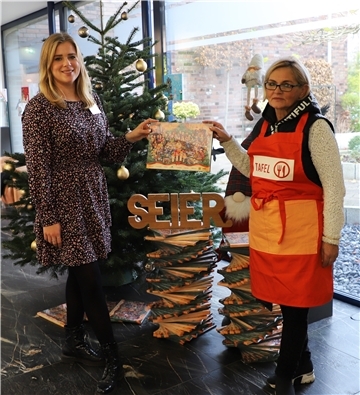 Tessa-Thalea Seier überreicht Adventskalender an Gaby Treschok von der Bremerhavener Tafel
