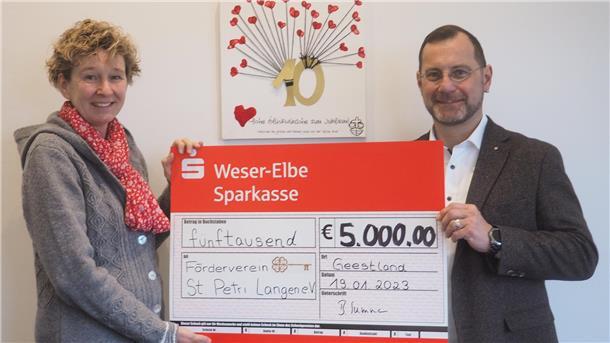 Steuerberaterin Bettina Summa übergibt den symbolischen Spendenscheck an Alexander Thorau, den Vorsitzenden des Fördervereins des St. Petri Kindergartens „Arche Noah“