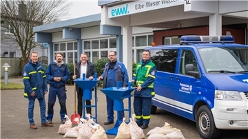 Die Elbe-Weser-Welten übergeben die handgefertigten Sandsackfülltrichter an das Technische Hilfswerk Bremerhaven. Im Bild (von links): THW-Vorsitzender Olaf May, EWW-Mitarbeiter Alexander Springer, EWW-Geschäftsführer Robert Bau, EWW-Mitarbeiter Martin Januschewski und THW-Berater Ibrahim Bulut. 