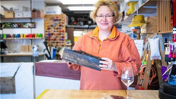 Schicksal der „Seuten Deern“ öffnet Herzen und Geldbeutel Eine Frau hält ein Stück Holz in den Händen