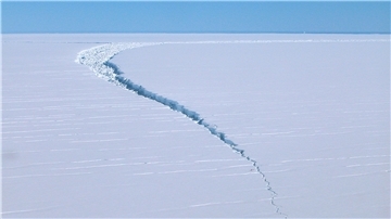 Ein Riss zieht sich durch einen Eisberg