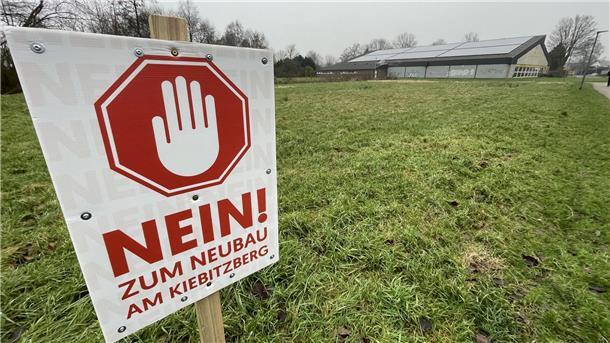 Nimmt die Stadt Nordenham die Sorgen ihrer Bürger nicht ernst? Schild mit der Aufschrift „Nein zum Neubau am Kiebitzberg" auf einer Rasenfläche.
